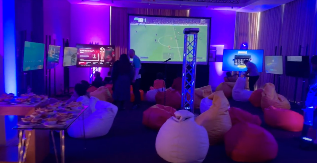Load video: A 3-minute video highlighting RetroGuySA's event gaming solutions service. The video shows a gaming setup for a 13th birthday party at the Crystal Towers in Cape Town, featuring 11 consoles and screens, with games like Minecraft, Fortnite, FC24, and Grand Theft Auto. The setup includes blue and purple lighting, bean bag chairs, and a snack table with gaming-themed treats.